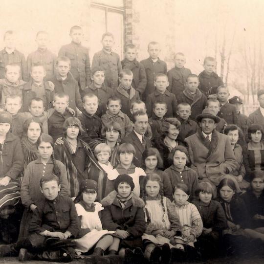  Grupa uczniów ze swoimi nauczycielami przed murowanym budynkiem starego Sądu, który wkrótce stanie się budynkiem szkolnym (1934)