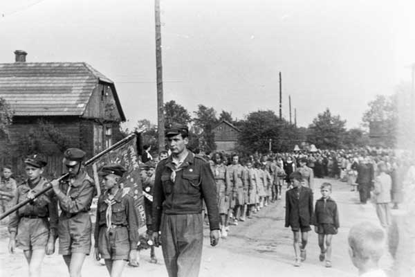 Rok 1947-48. Drużyny harcerskie z Kłomnic podczas przemarszu ze sztandarem ulicami Kłomnic
