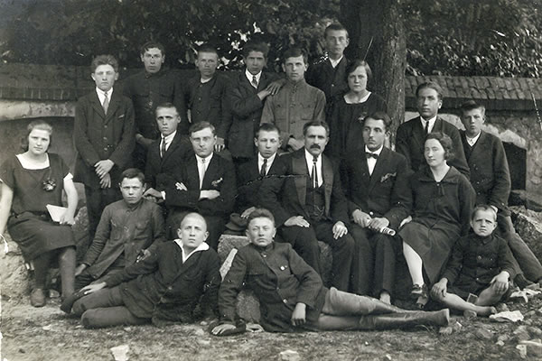 Około roku 1925 -26. Nauczyciele i grupka uczniów ze Szkoły Powszechnej w Kłomnicach pod murem otaczającym kościół parafialny w Kłomnicach. 