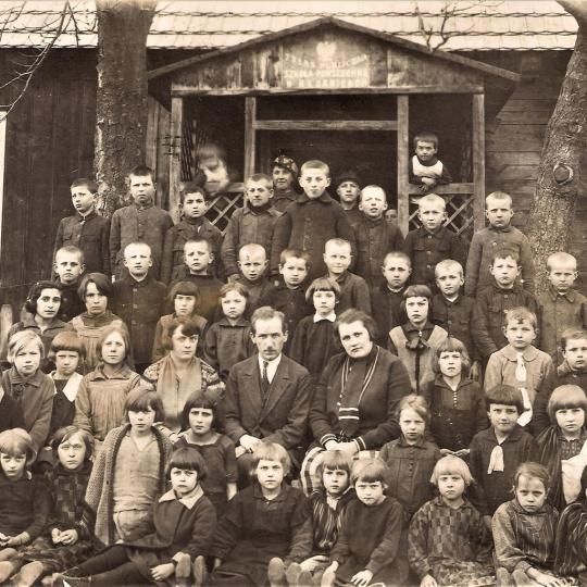 Uczniowie i nauczyciele przed budynkiem „7-klasowej Publicznej Szkoły Powszechnej w Kłomnicach” wybudowane w 1896 r.