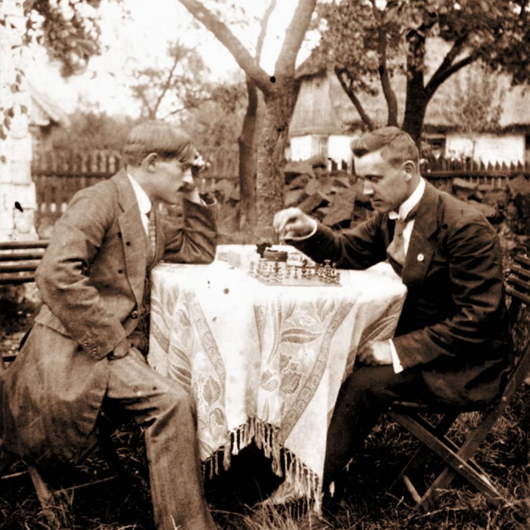 Wacław Centkowski w swoim ogrodzie z kolegą przy stoliku podczas gry w szachy.